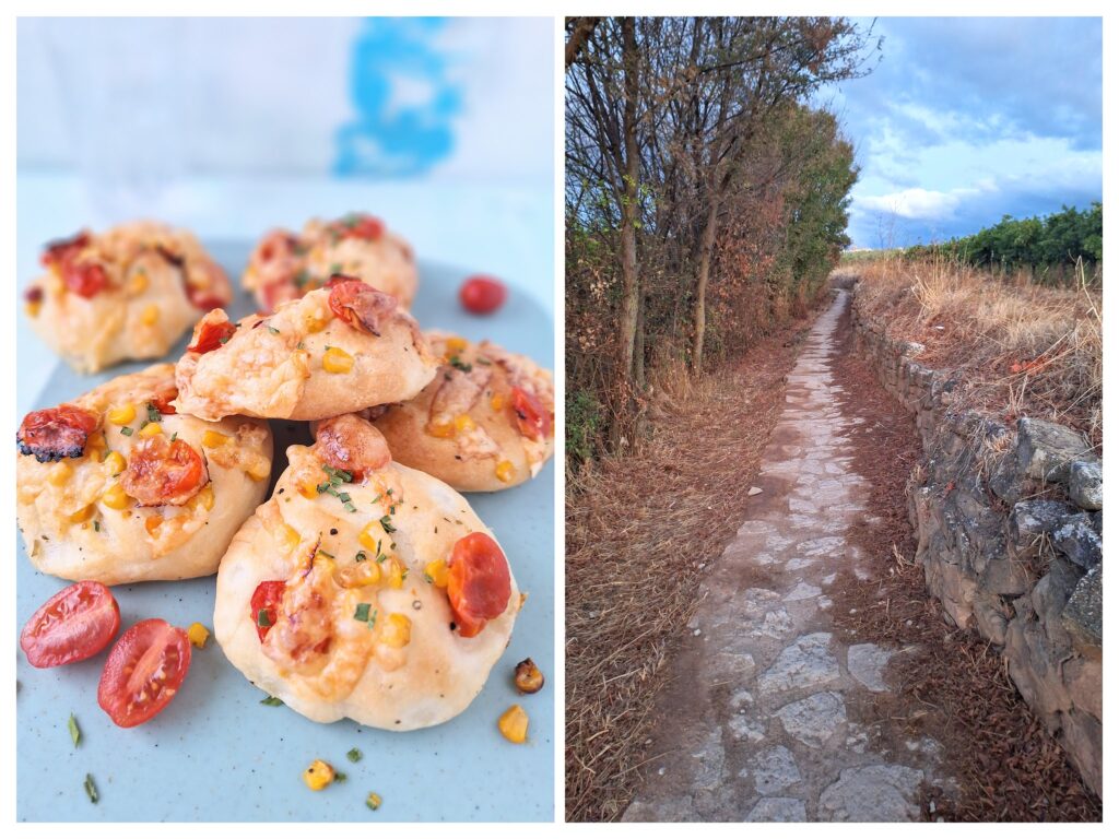 Selbstgemachte Pizza-Brötchen und ein schmaler Weg mit Steinmauer in Spanien bei Puenta de la Reina.