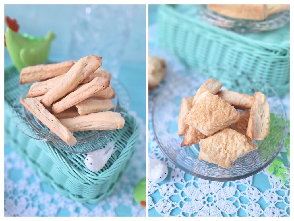 Knusprige Zucker-Ecken und Stangen-Kekse auf einem grünen Korb und Vogeldekoration auf einer gehäckelten weißen Tischdecke.