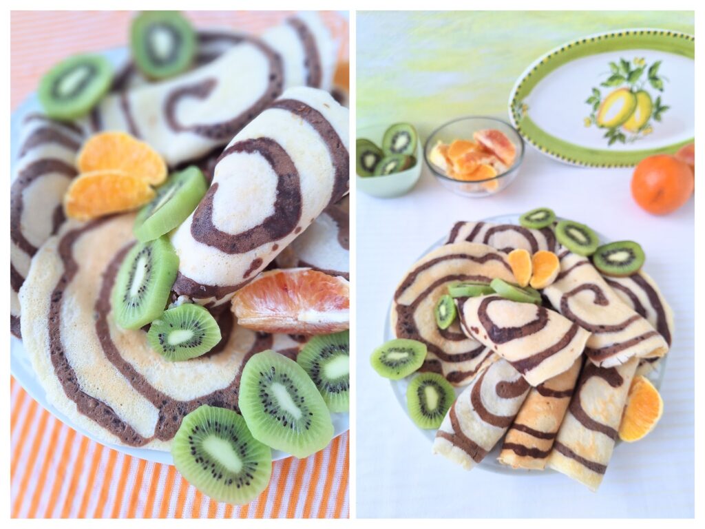 Selbstgemachte Crepes mit Schokowirbel-Muster und frisch Kiwi und Orangen.
